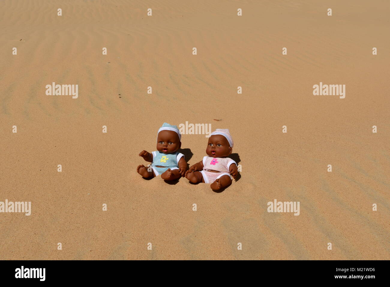 Ragazzo bambole nella sabbia, pelle scura bambole Foto Stock
