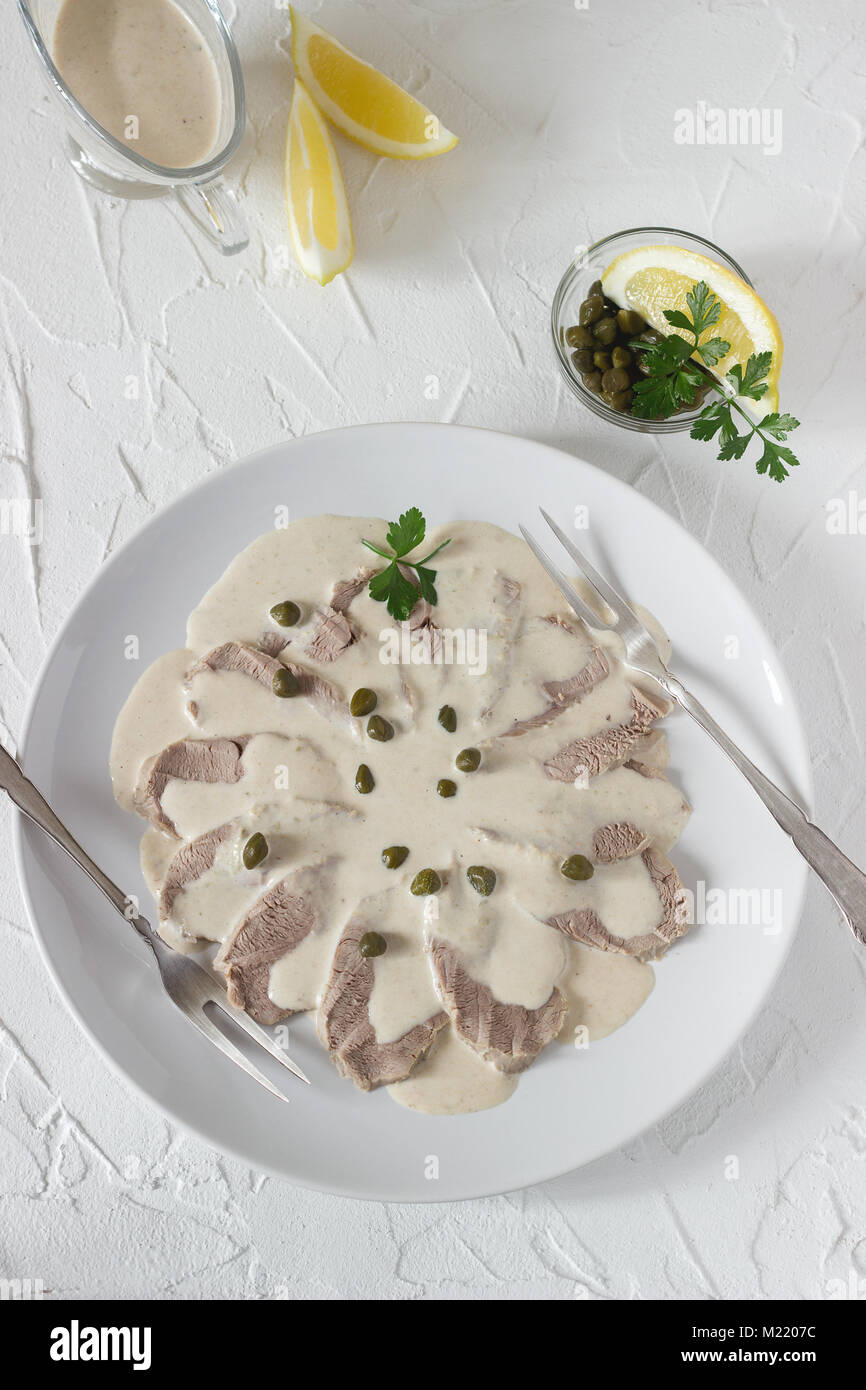 Vitello tonnato è un tradizionale piatto italiano su un cemento bianco sullo sfondo. Messa a fuoco selettiva. Foto Stock