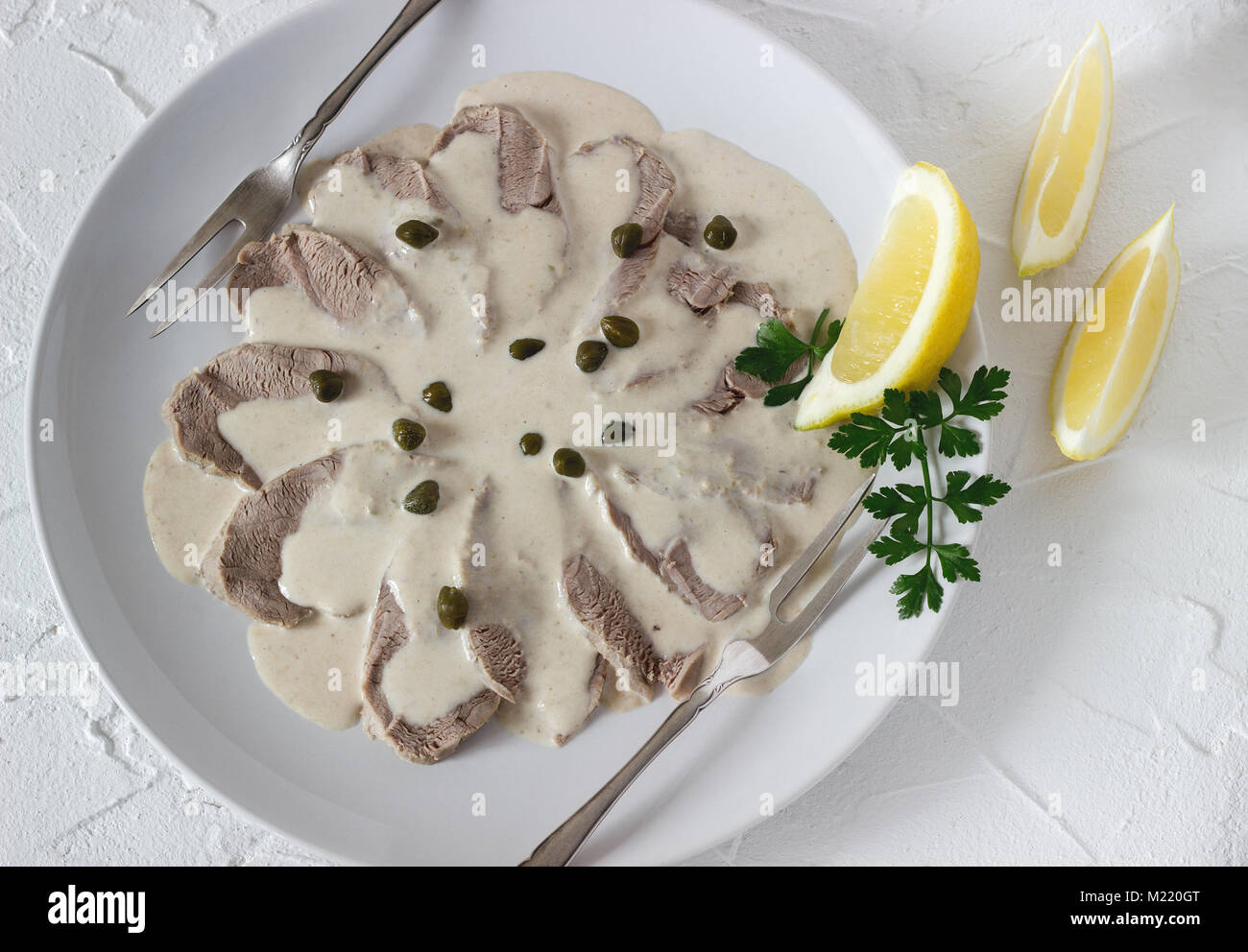 Vitello tonnato è un tradizionale piatto italiano su un cemento bianco sullo sfondo. Messa a fuoco selettiva. Foto Stock