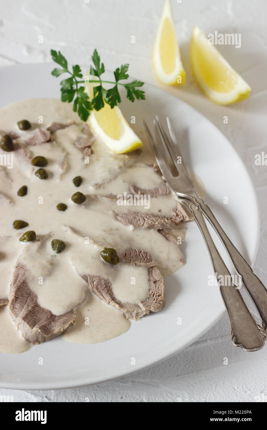 Vitello tonnato è un tradizionale piatto italiano su un cemento bianco sullo sfondo. Messa a fuoco selettiva. Foto Stock