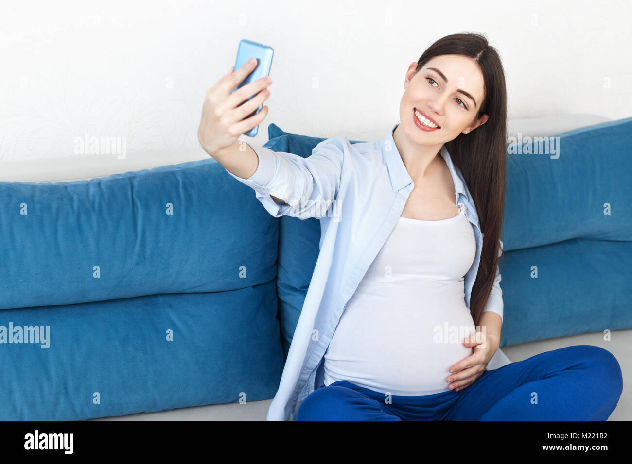 Donna incinta prendendo selfie Foto Stock