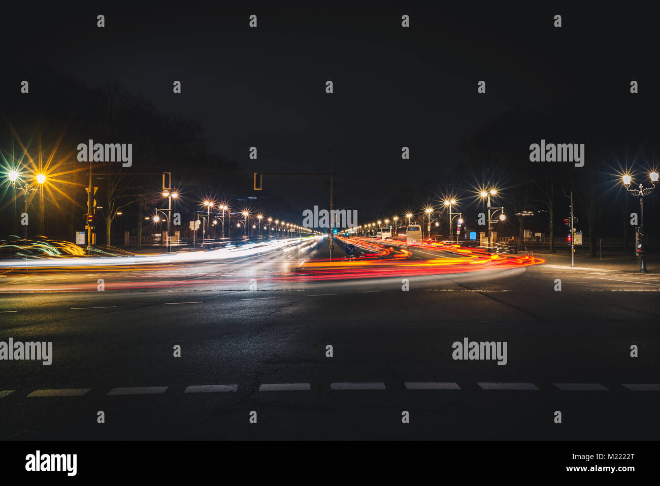 Lungo una strada di città con percorsi di luce di notte. Una lunga esposizione foto di dritto strada ampia a Berlino Foto Stock