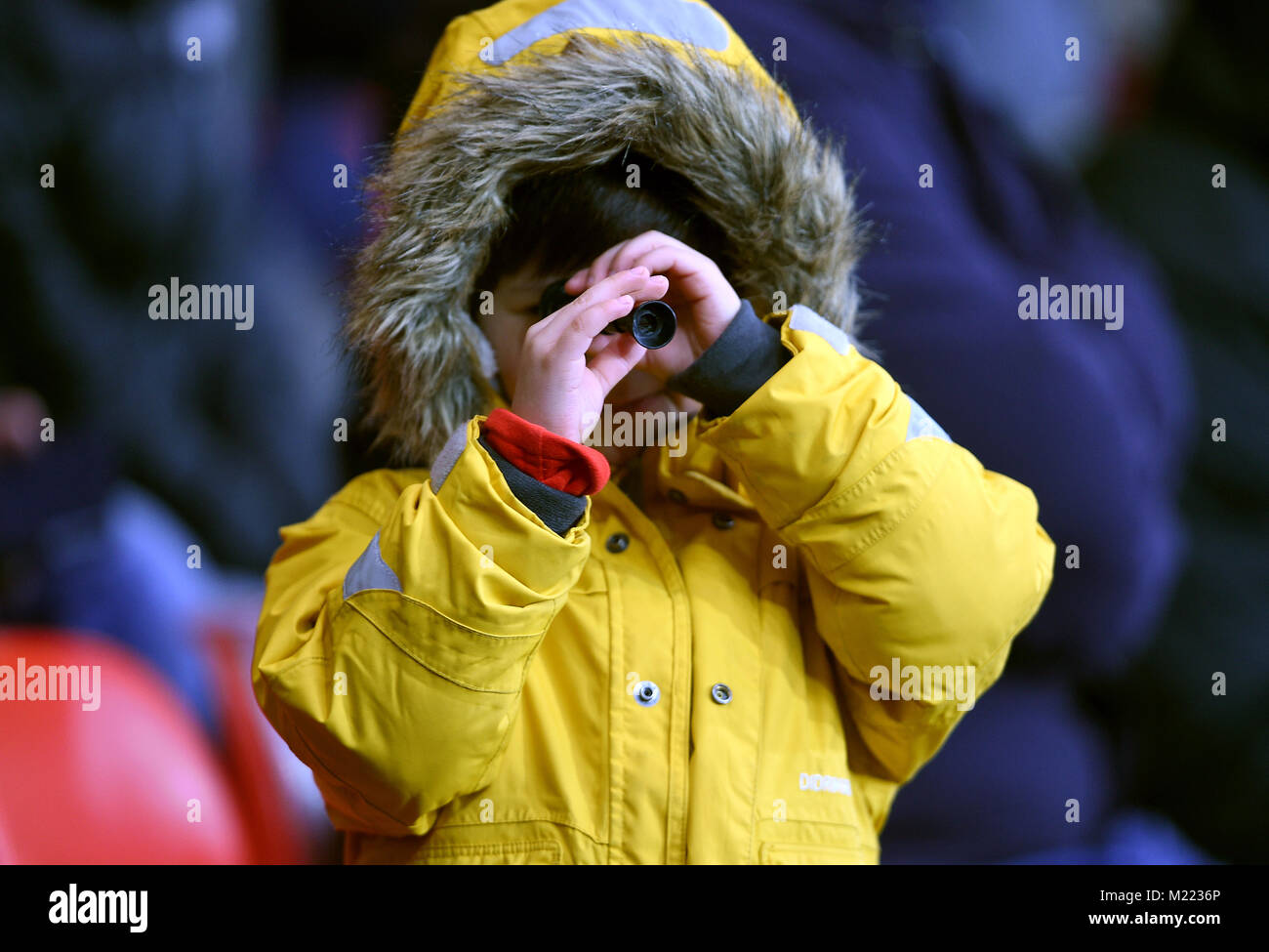 Un giovane fan in gabbie guarda attraverso un piccolo cannocchiale durante il match di Premier League alla vitalità Stadium, Bournemouth. Foto Stock