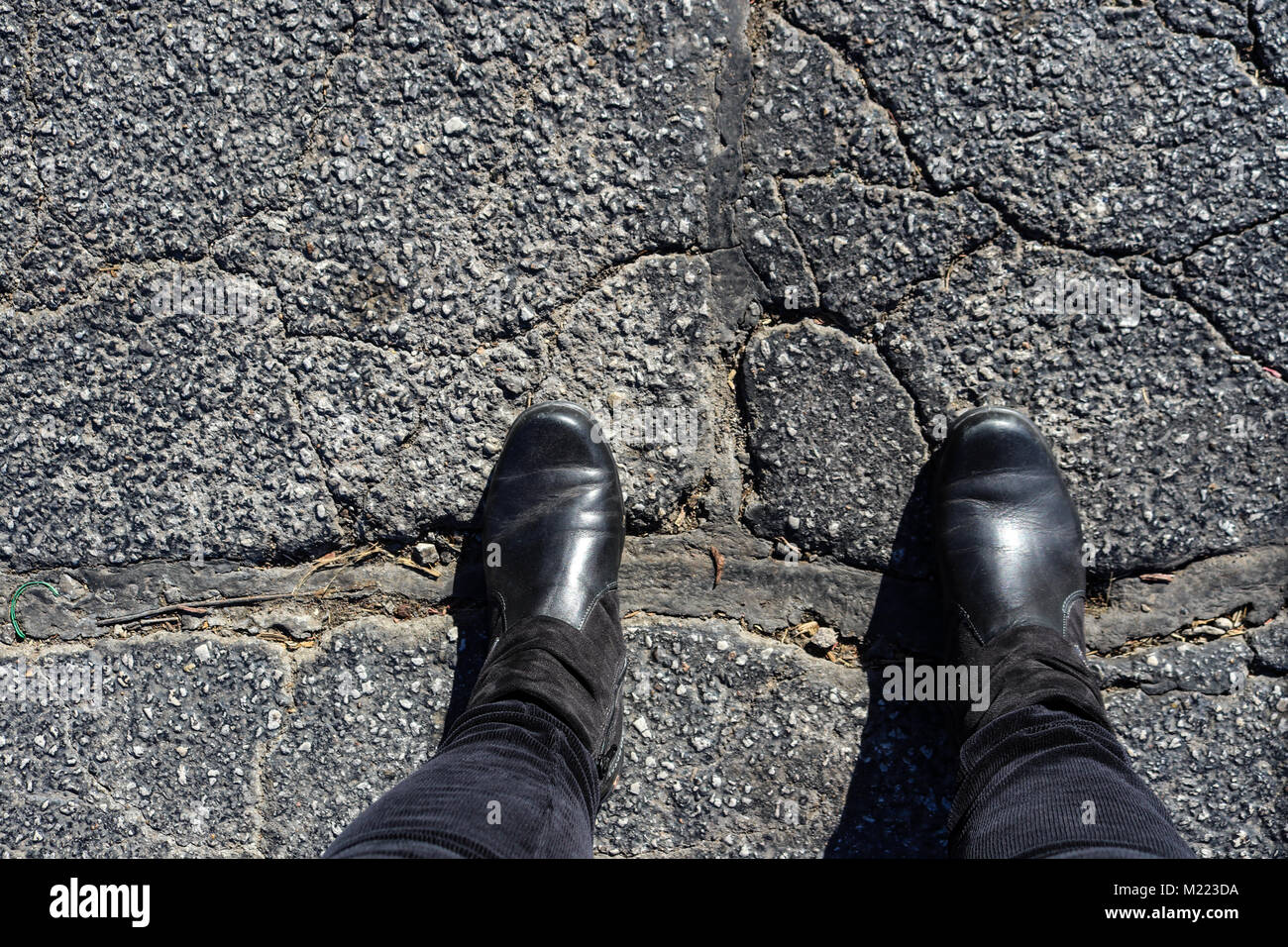 Colmare il divario - Piedi di donna in stivali neri cavalletti con piedi  attraverso grandi riparazione in asfalto screpolato Foto stock - Alamy