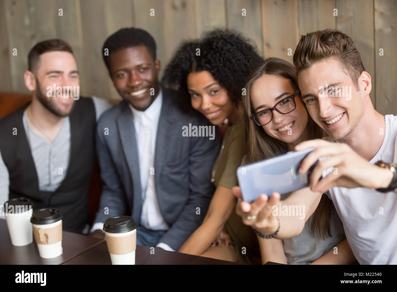 Giovane uomo prendendo selfie sullo smartphone all incontro con gli amici Foto Stock