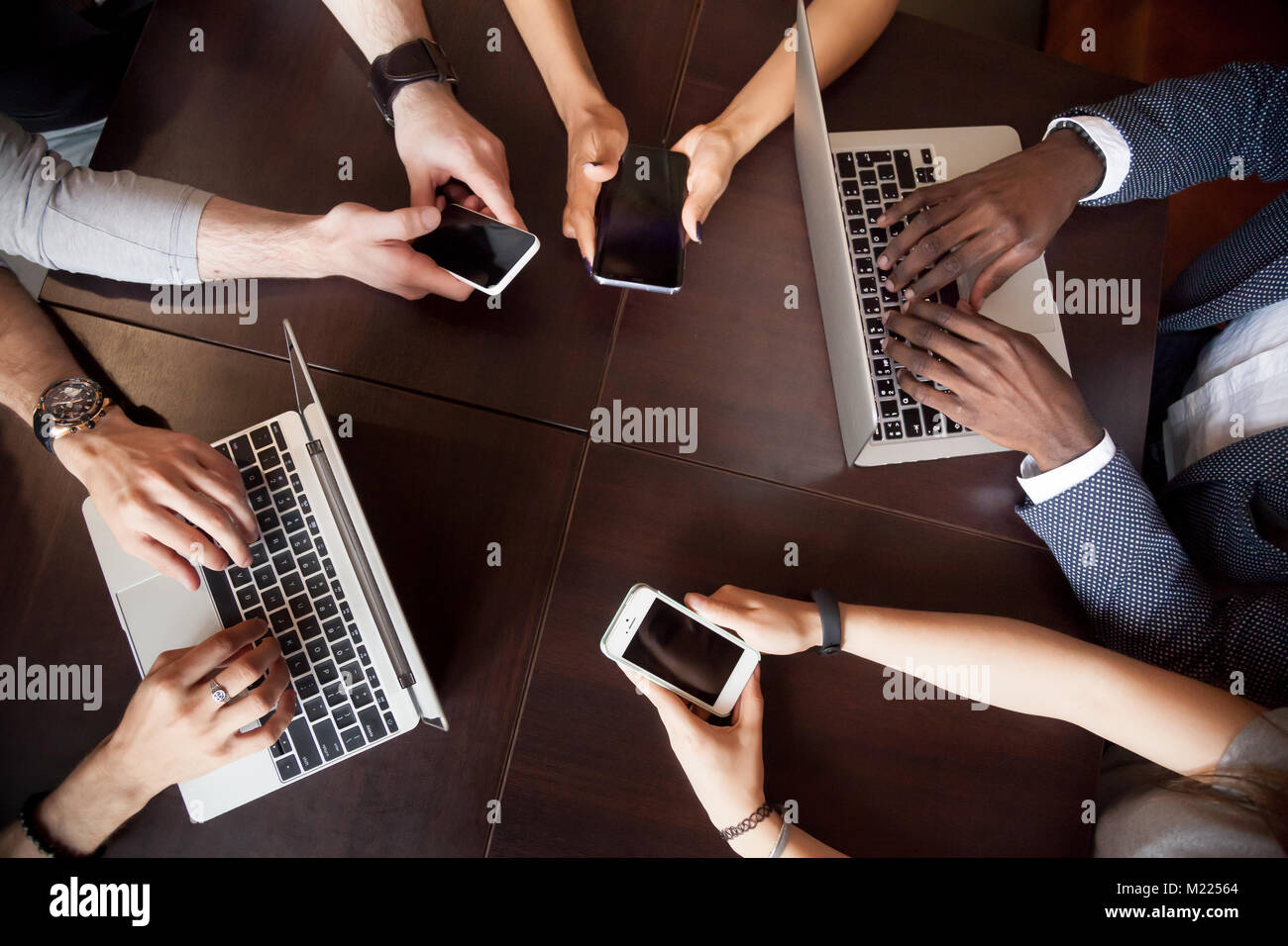 Diverse persone e multirazziale utilizzando computer portatili smartphone sul tavolo, t Foto Stock