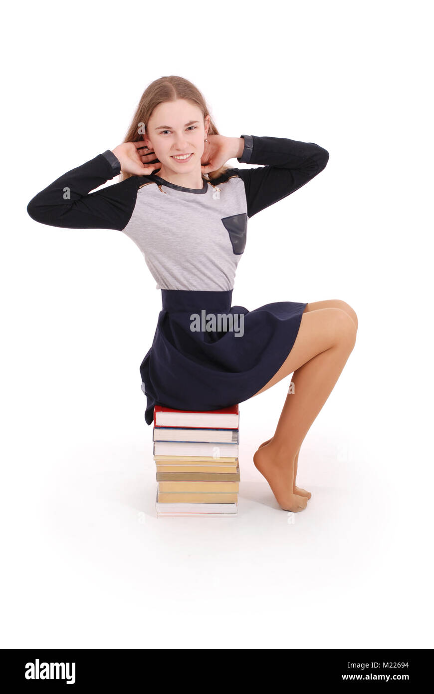 Istruzione, persone, adolescente e il concetto di scuola - scuola di adolescente ragazza seduta sulla pila di libri. Isolato su bianco Foto Stock