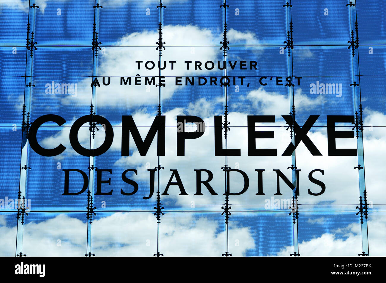 Segno per Complexe Desjardins, un importante centro dello shopping nel centro di Montreal, Canada. Scritte su una grande finestra baia contro un cielo blu sullo sfondo. Foto Stock