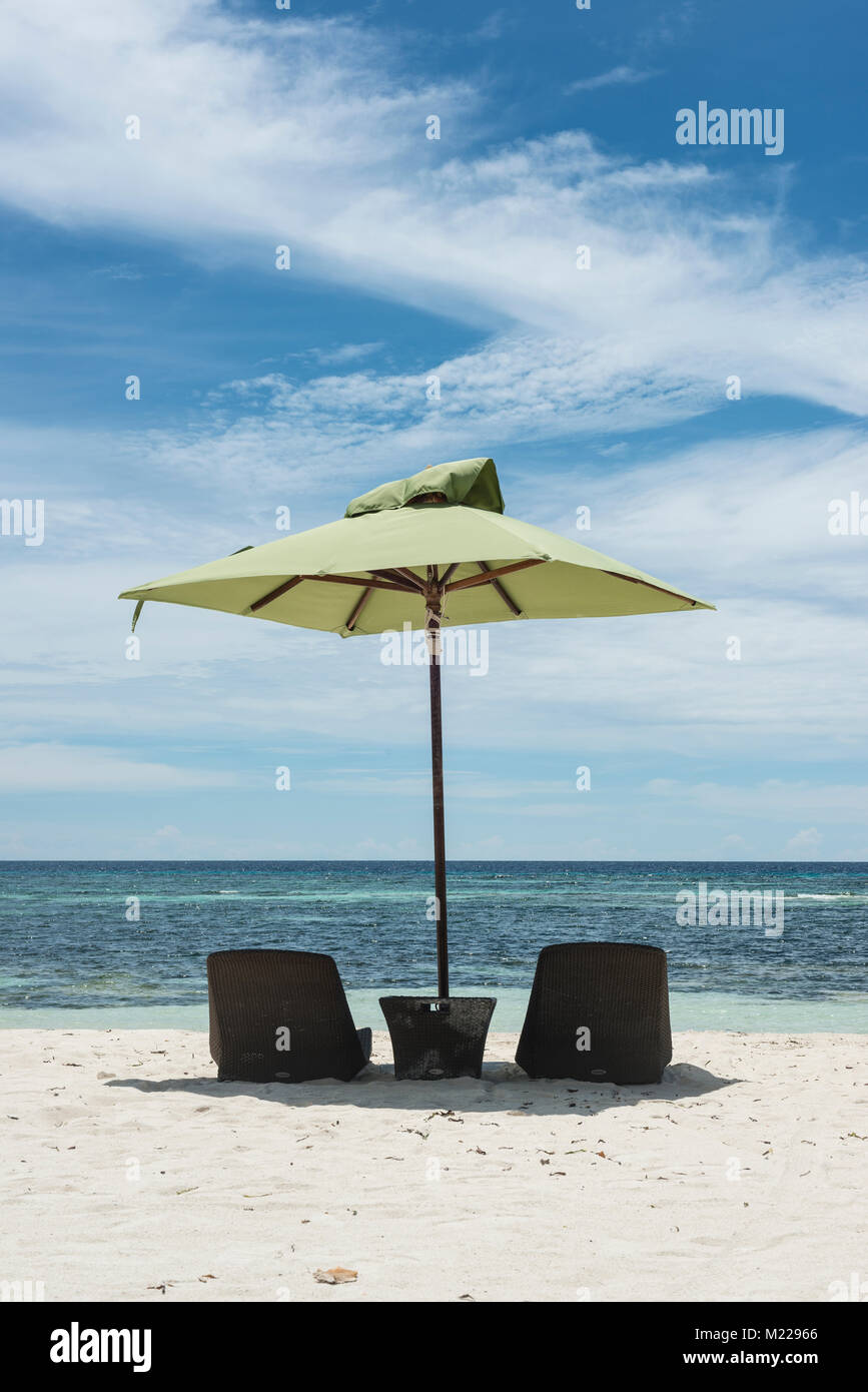 Le sedie a sdraio e gli ombrelloni su un tropicale, spiaggia bianca Foto Stock