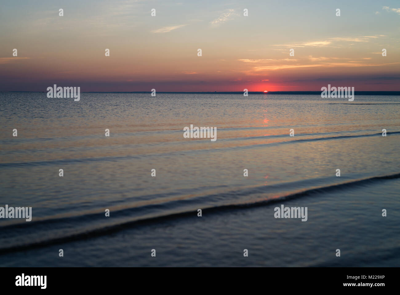 Tramonto sulla spiaggia sul Mar Baltico con acqua calma Foto Stock