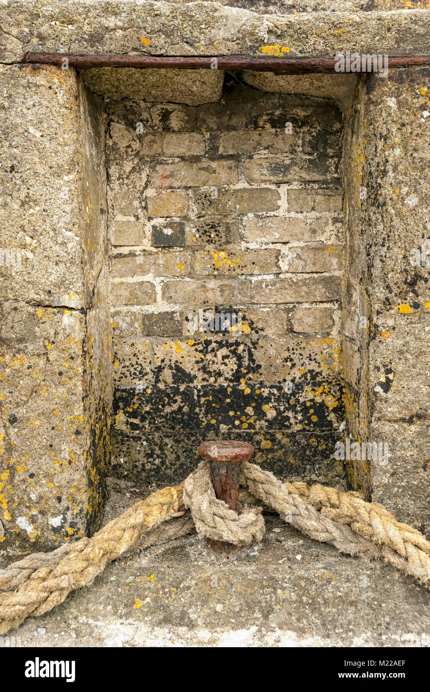 Vecchio bollard metallico e la cima di ormeggio a Charlestown Harbour Foto Stock