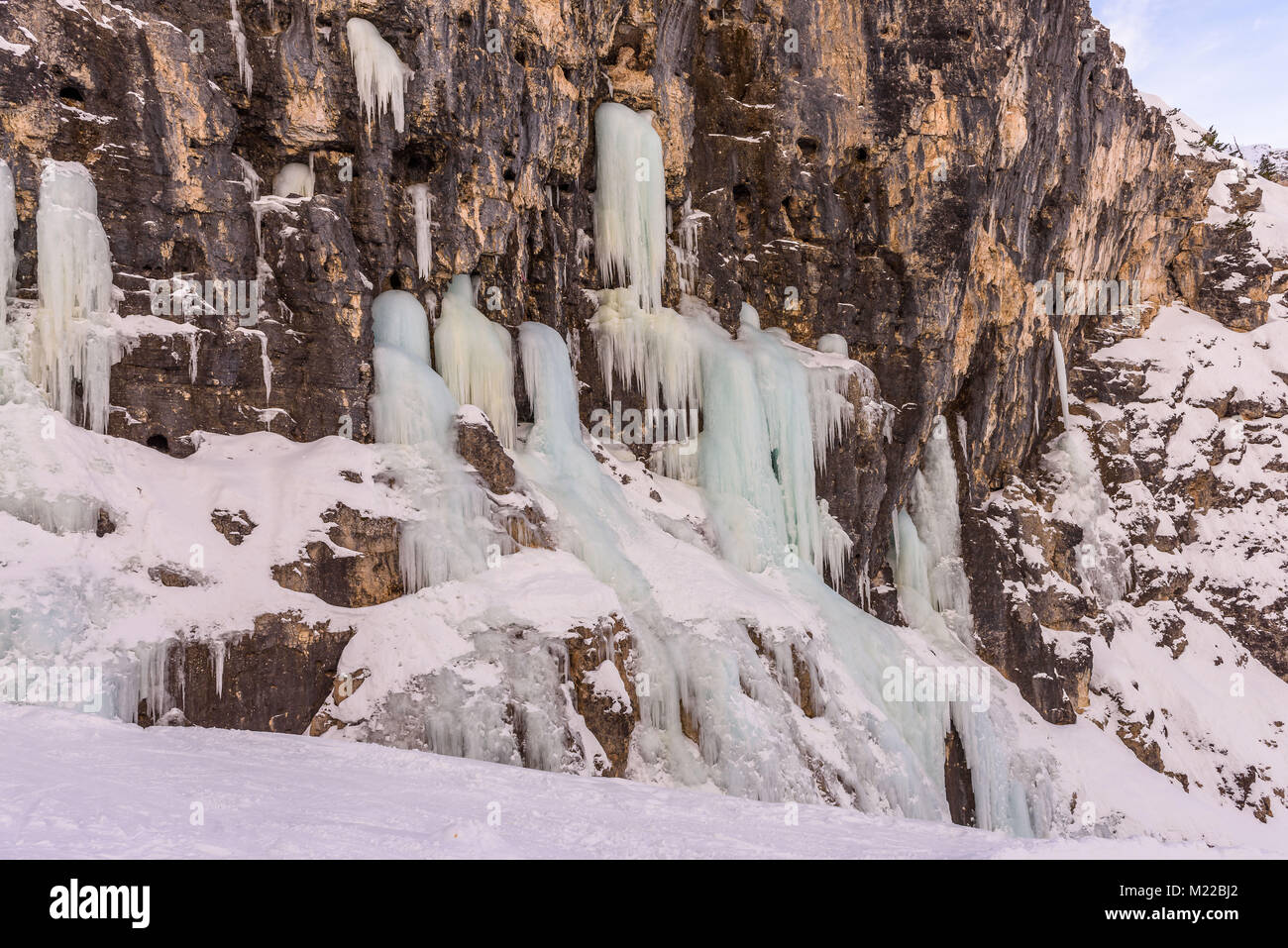 Vista invernale di una cascata di ghiaccio lungo il pendio del Lagazuoi nelle Dolomiti Foto Stock
