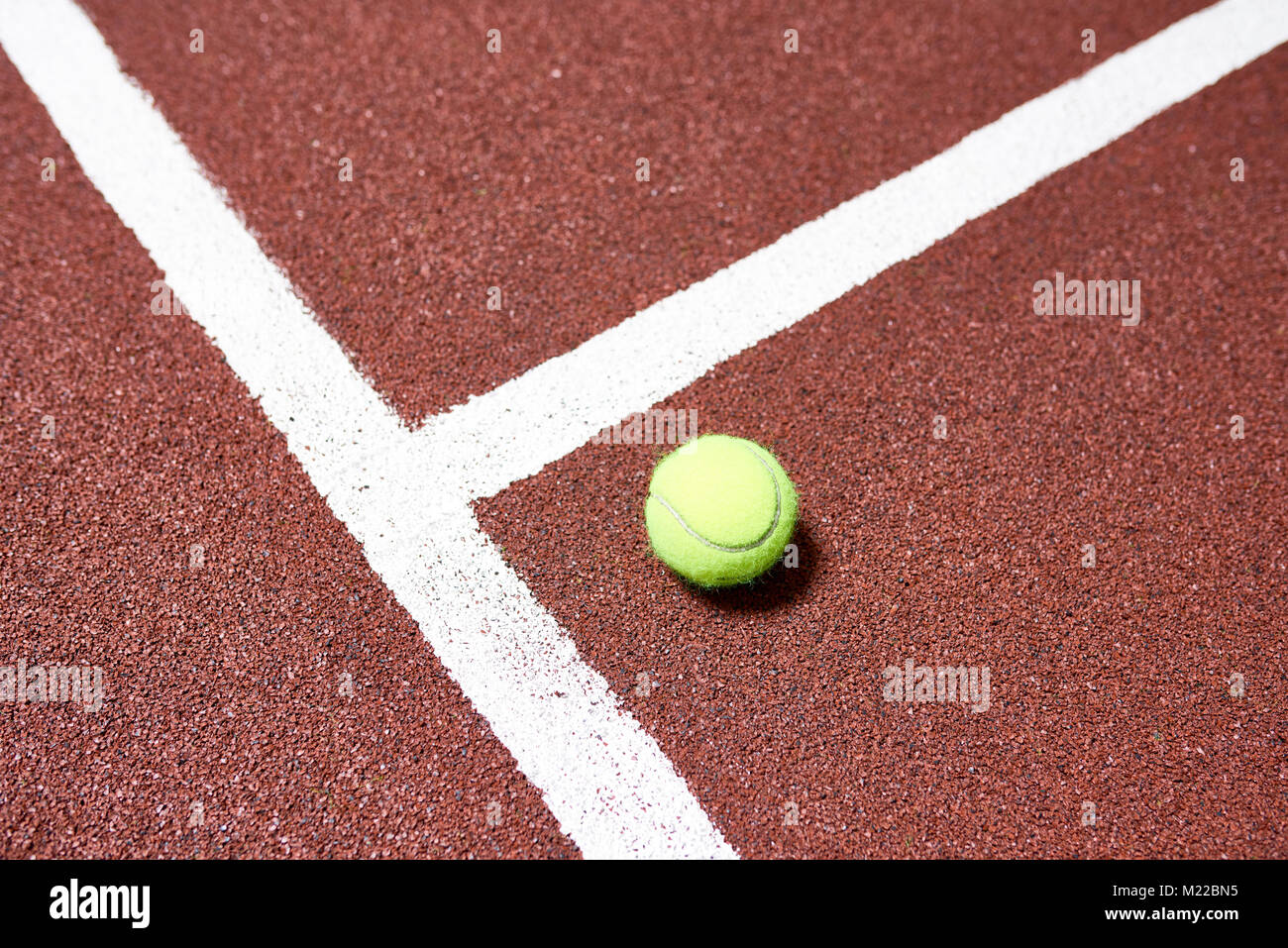 Vista sopra lo sfondo giallo della palla da tennis sdraiato sul pavimento di corte in presenza di luce solare, spazio di copia Foto Stock
