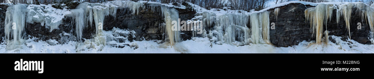 Superwide panorama con ghiaccioli appeso ad una parete di roccia in formazioni di bello Foto Stock