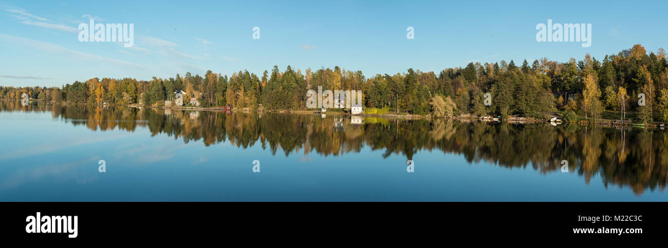 Panorama della riflessione di una foresta in un lago in Nummela, Finlandia Foto Stock