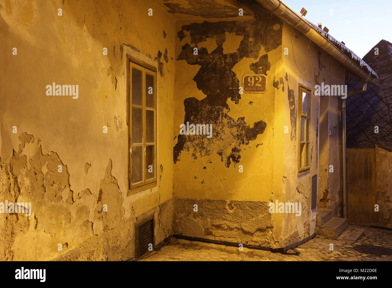 Intonaco rotto di una vecchia casa nel centro storico della città di Tabor al crepuscolo Foto Stock