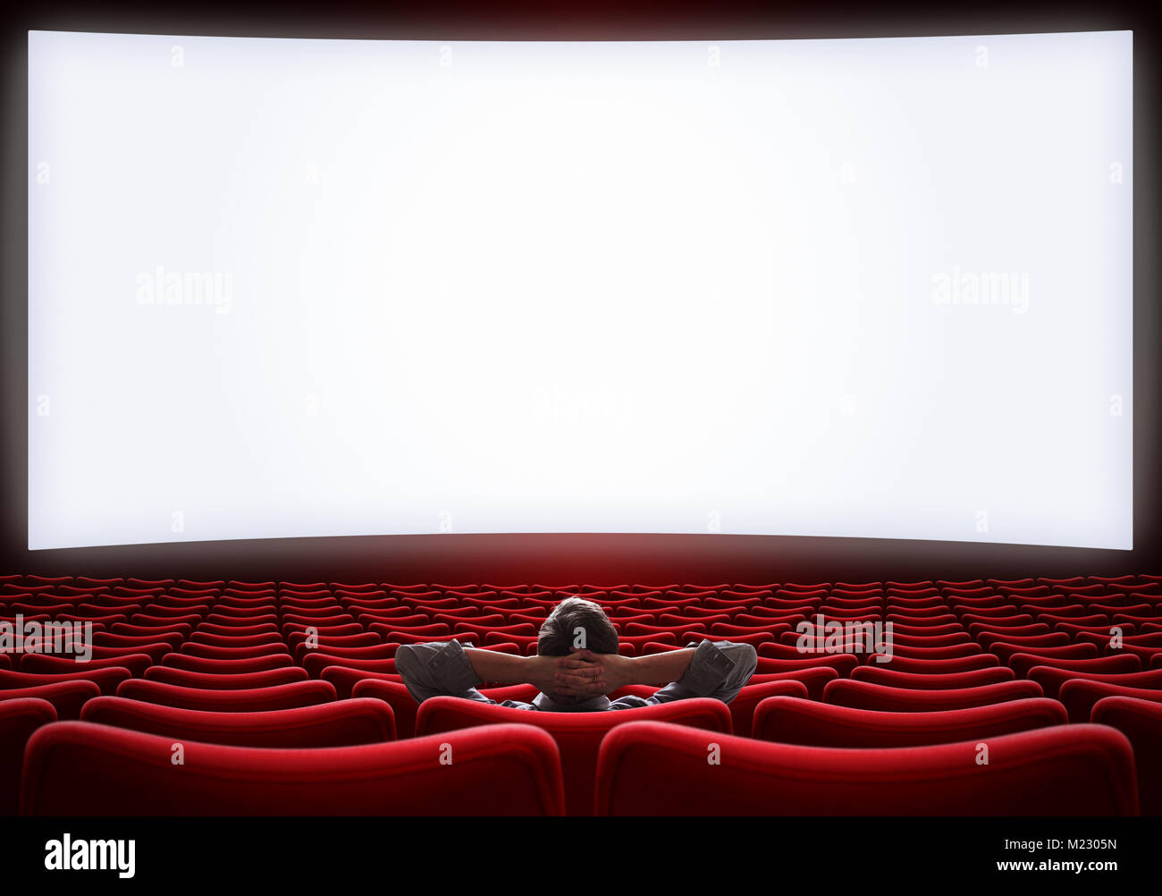 Svuotare sala cinema con lonely uomo seduto al centro Foto Stock