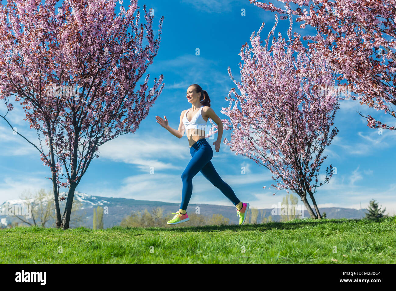 Donna in corsa per il fitness in un giorno di primavera Foto Stock