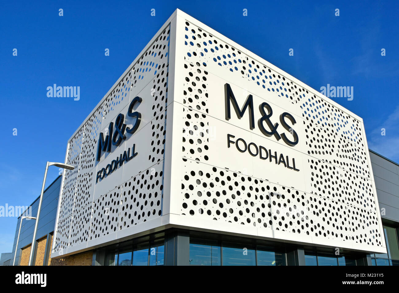 Design moderno a punti dello scudo anteriore e firma la nuova M&S. Foodhall moderno edificio all'angolo della Torre dell'Orologio al dettaglio Park Chelmsford Essex Inghilterra Regno Unito Foto Stock