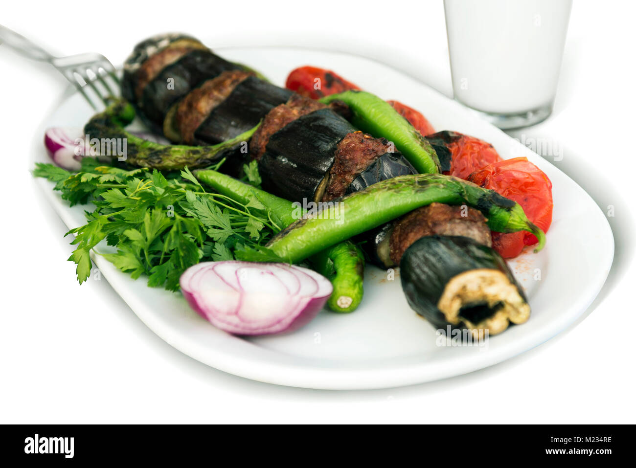 Le melanzane kebab in turco Patlican Kebap, su sfondo bianco e la piastra bianca. Foto Stock