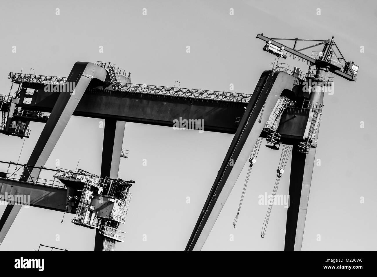 Cantiere di Danzica, Polonia. In stile retrò in bianco e nero. Gru, il cantiere di vecchi edifici, strutture arrugginite. Foto Stock