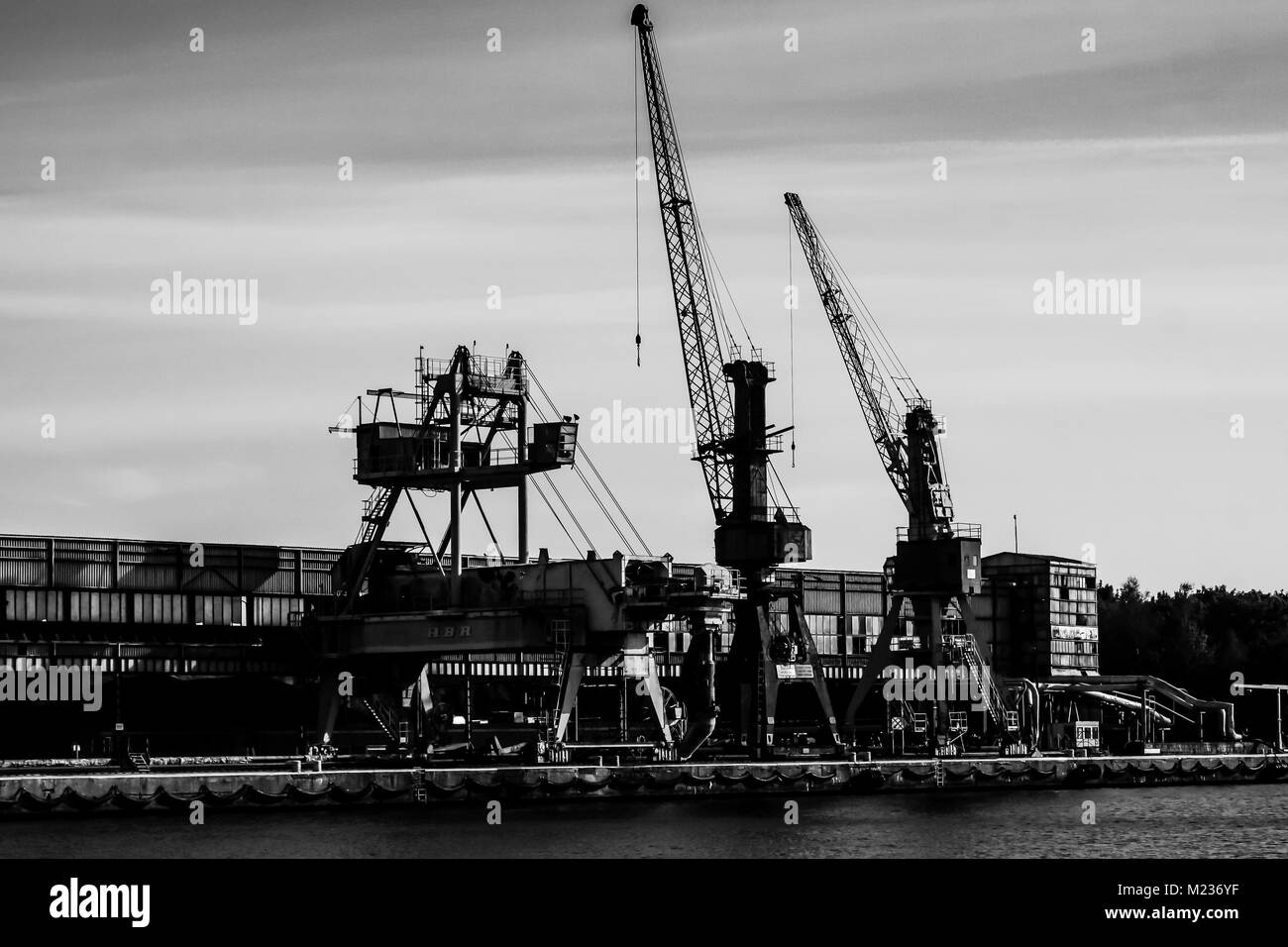 Cantiere di Danzica, Polonia. In stile retrò in bianco e nero. Gru, il cantiere di vecchi edifici, strutture arrugginite. Foto Stock