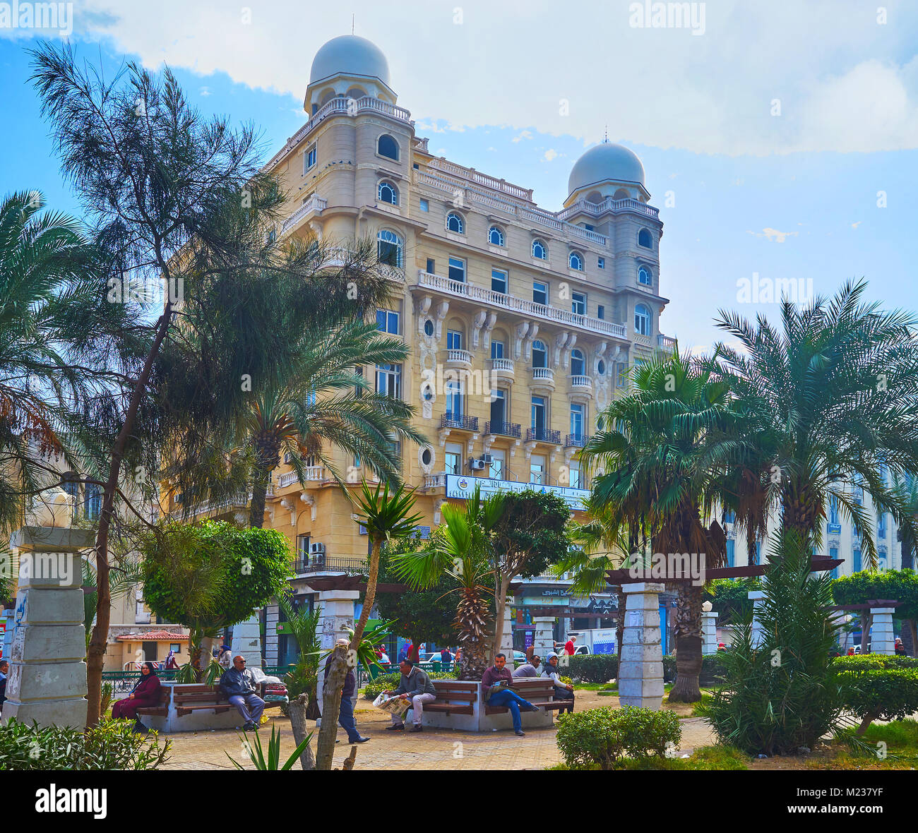 Alessandria, Egitto - 17 dicembre 2017: la vista sul lussuoso edificio storico del Majestic Hotel, che serve come il centro commerciale per lo shopping, attraverso il verde Foto Stock