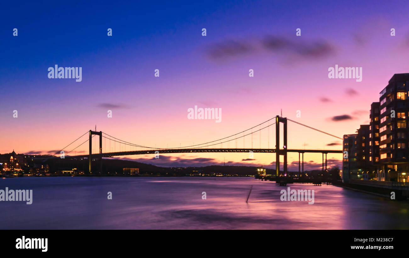 Si tratta di un ponte di sospensione di Göteborg, Lnadmark di architettura svedese. Colpo da barca blu durante l'ora. Impostazione sun creando bellissimi colori. Foto Stock