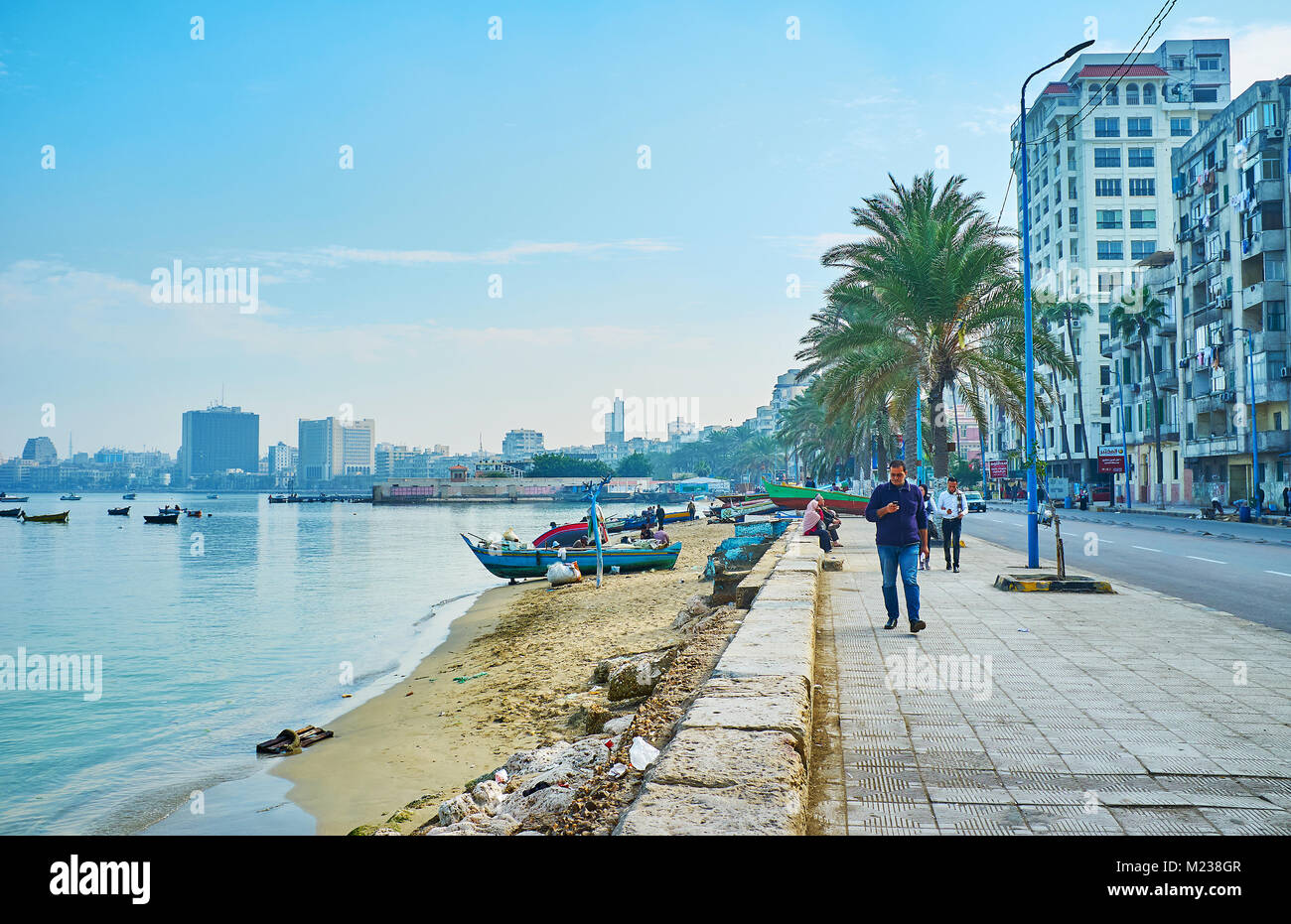 Alessandria, Egitto - 17 dicembre 2017: il lazy passeggiata alla Corniche passeggiata sul lungomare con vista sul porto orientale alloggiamento dei vecchi quartieri di un Foto Stock