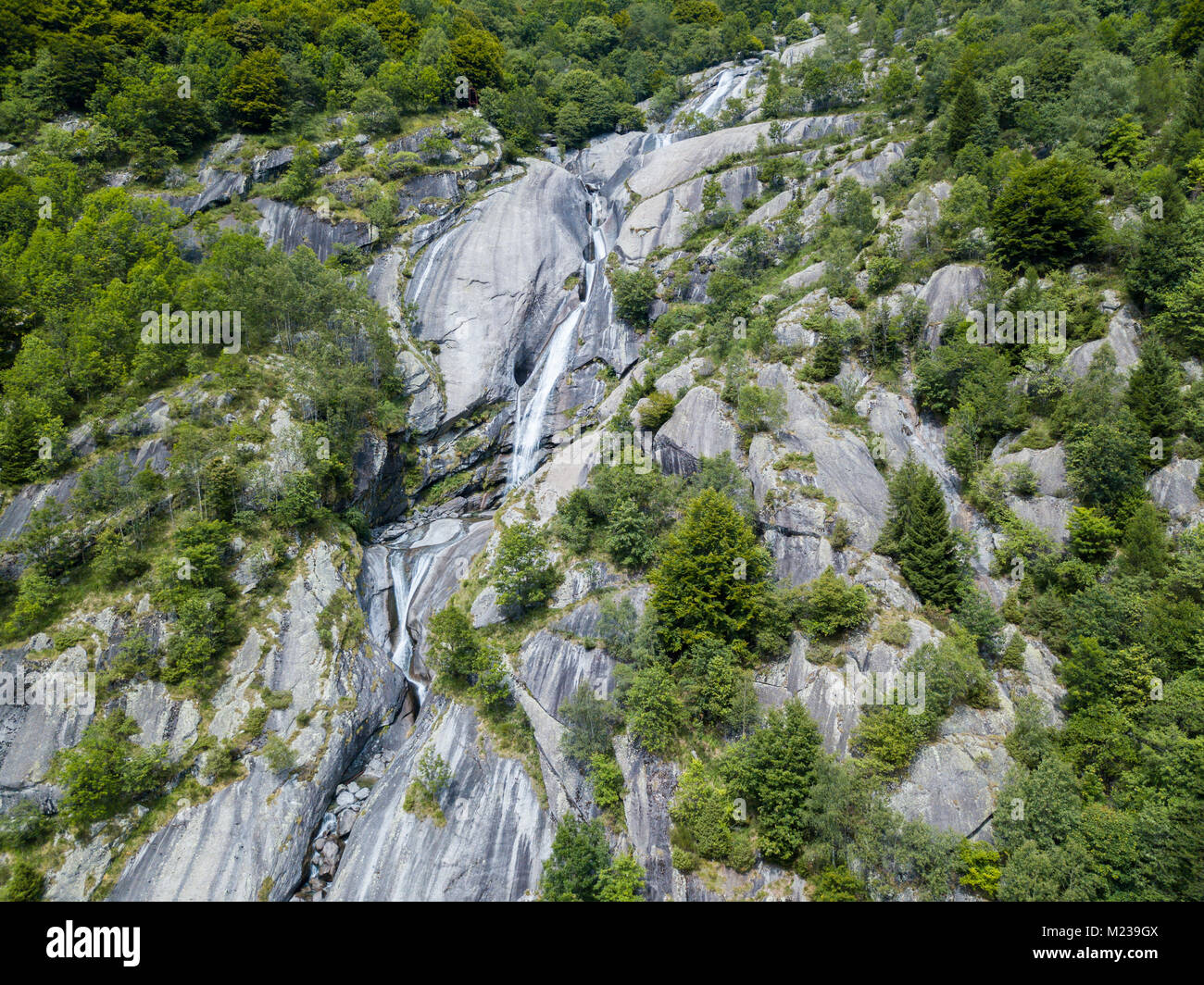 Vista aerea di una cascata in Val di Mello, una verde vallata circondata da montagne di granito e boschi, rinominato l'Italiano Yosemite Valley Foto Stock