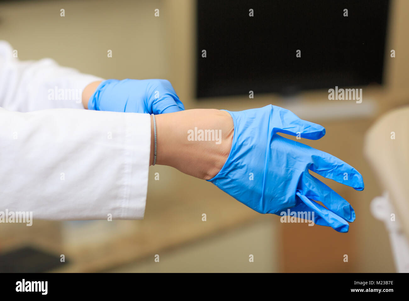 Abito medico guanti sulle mani sul fondo della camera operativa.  L'infermiera mettendo su guanti sterili Foto stock - Alamy