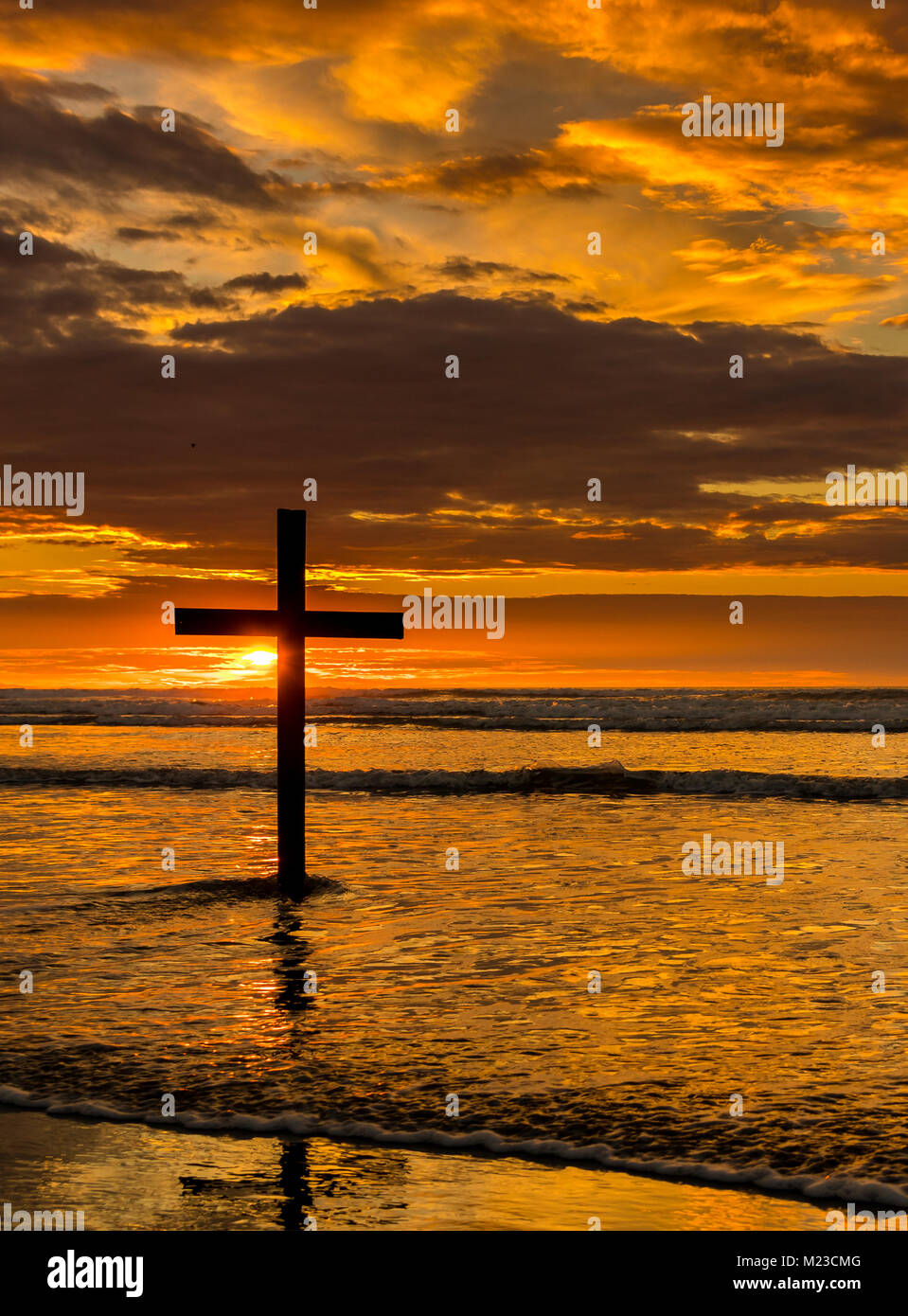 Croce scuro su una spiaggia con un meraviglioso Cielo di tramonto. Foto Stock