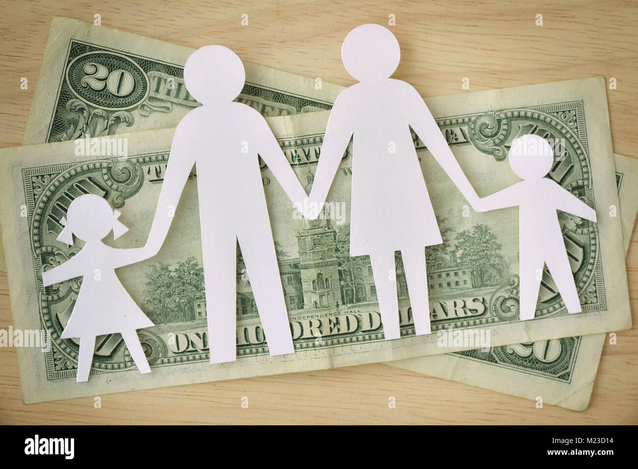 Famiglia di carta ritagliata sulle banconote di dollari - Famiglia concetto di bilancio Foto Stock