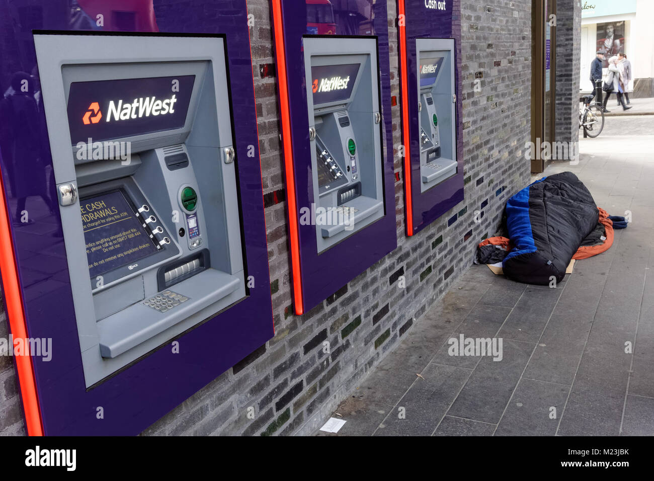 Persona che dormiva ruvida accanto a Natwest ATM Bancomat in London, England, Regno Unito, Gran Bretagna Foto Stock