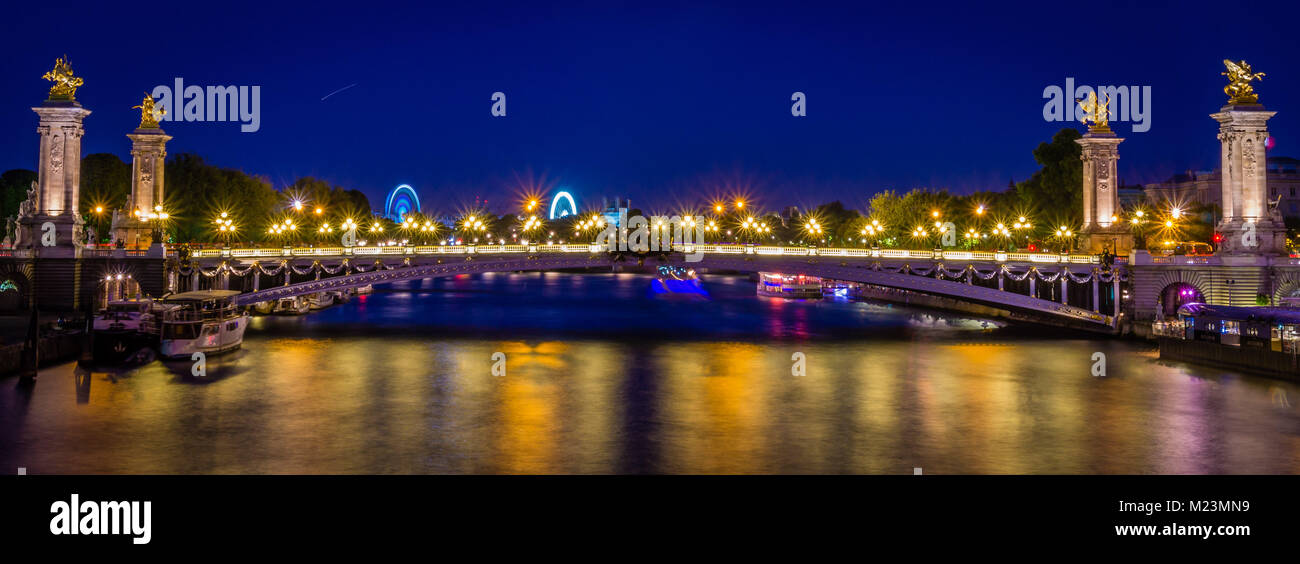 Alessandro II ponte in Parigi di notte con ruote di grande diametro in background Foto Stock