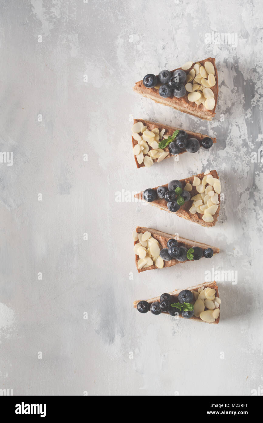 Vegan materie cioccolato cheesecake con mirtilli e mandorle. Un sano pasto vegano concetto, cibo sfondo, vista dall'alto Foto Stock