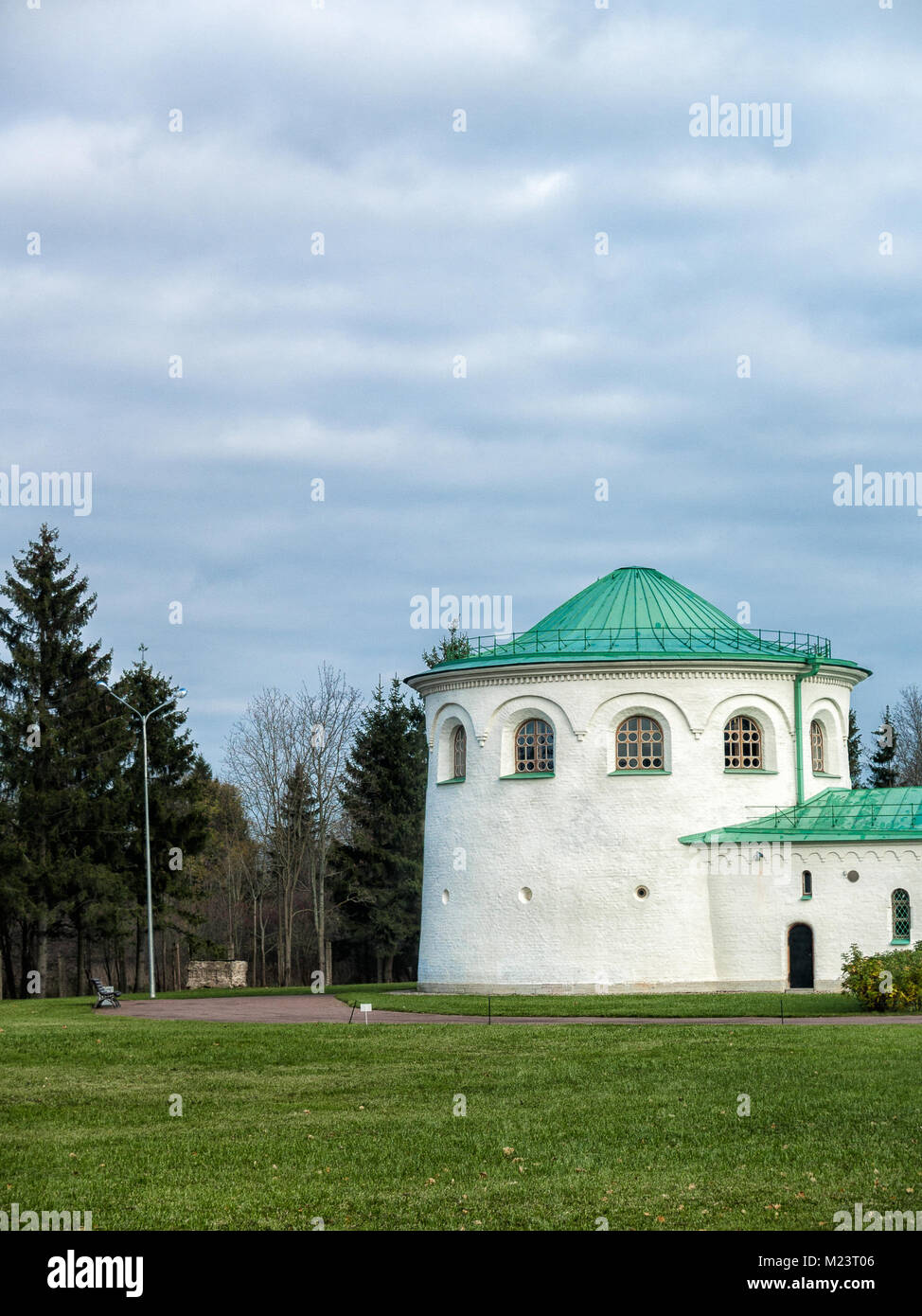 Parte del complesso architettonico Ratnaya Camera in Tsarskoe Selo in Alexander Park con un prato, un banco, un percorso, una foresta in nuvoloso meteo in t Foto Stock