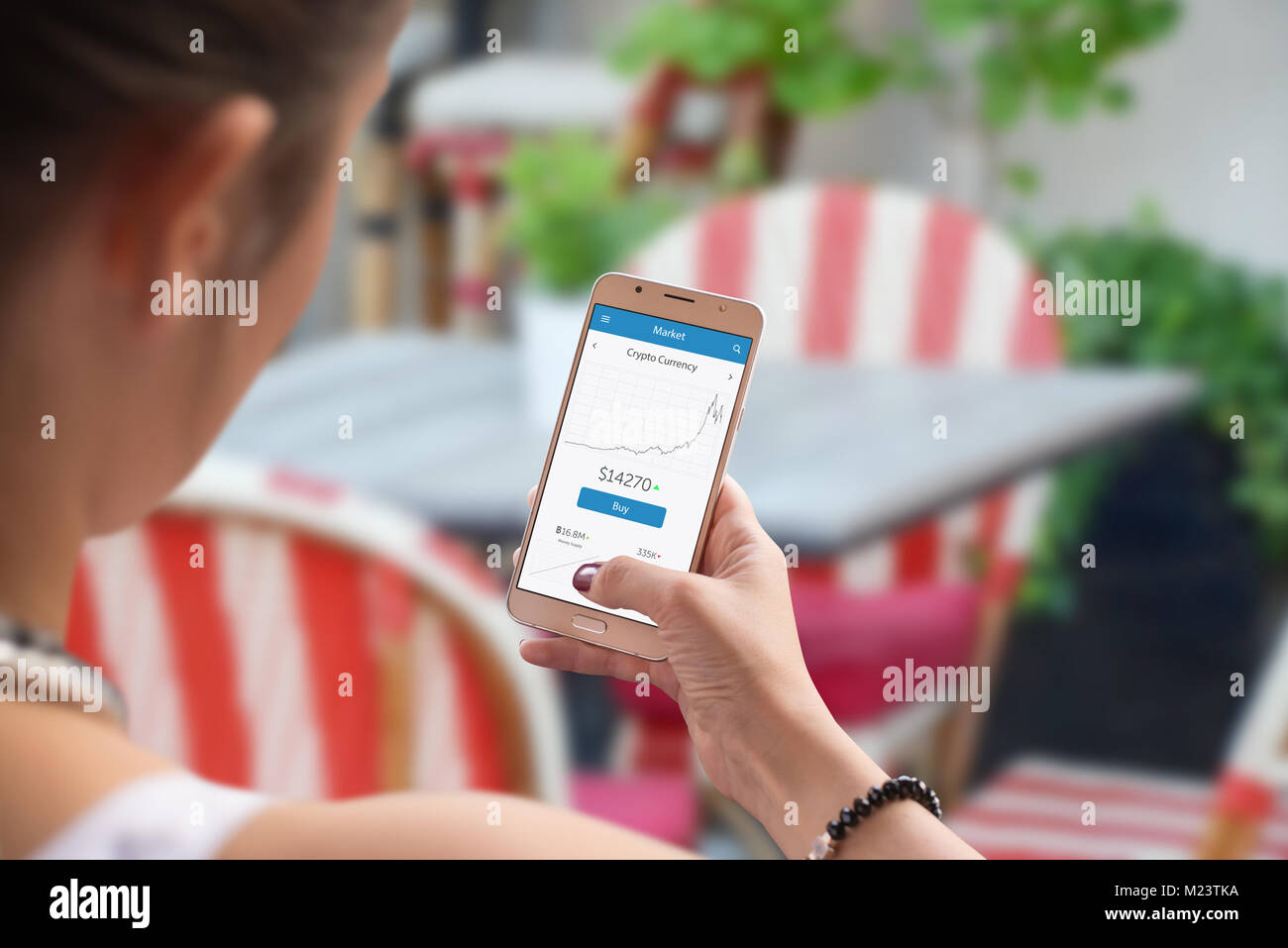 Nuova moneta virtuale stats su schermo di cellulare nella donna la mano. Bar o ristorante in background. Foto Stock