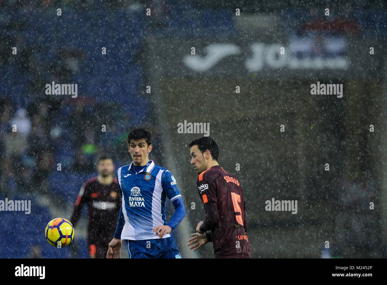 4. febbraio 2018, Cornella-El Prat, Cornella de Llobregat, Barcellona, Spagna; La Liga calcio, Espanyol rispetto a Barcellona; Gerard Moreno dell Espanyol e Busquets di Bara sotto la pioggia Foto Stock