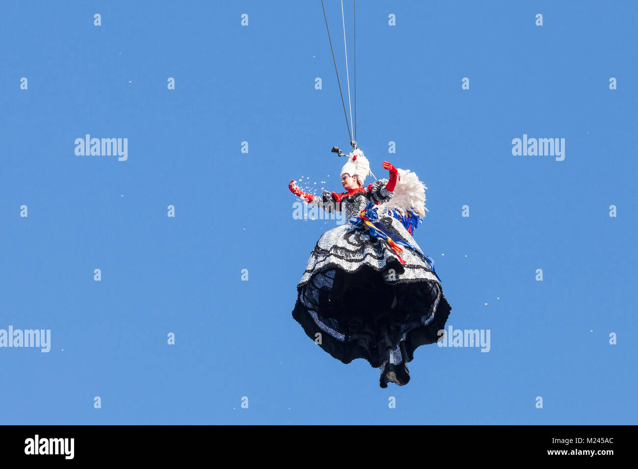 Venezia, Veneto, Italia il 4 febbraio 2018. Volo dell'Angelo durante il 2018 il Carnevale di Venezia con la Maria dal 2017, Elisa Costantini, volare giù dal Campanile della Basilica di San Marco sul palco di Piazza San Marco a rendere omaggio al Doge, sospeso a mezz'aria contro il cielo blu. Il suo costume è stato progettato da Stefano Atelier Nicolao. Foto Stock