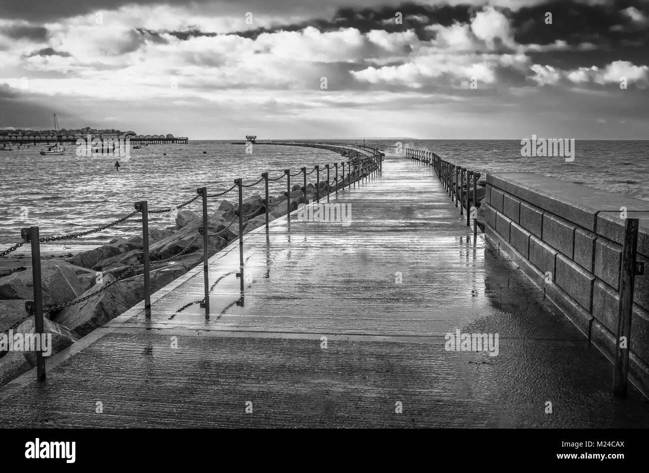 Immagine in bianco e nero del frangiflutti noti come Nettuno in braccio Herne Bay, Kent, Regno Unito durante una marea alta quando la passerella bagnata era chiuso a causa delle forme d'onda Foto Stock