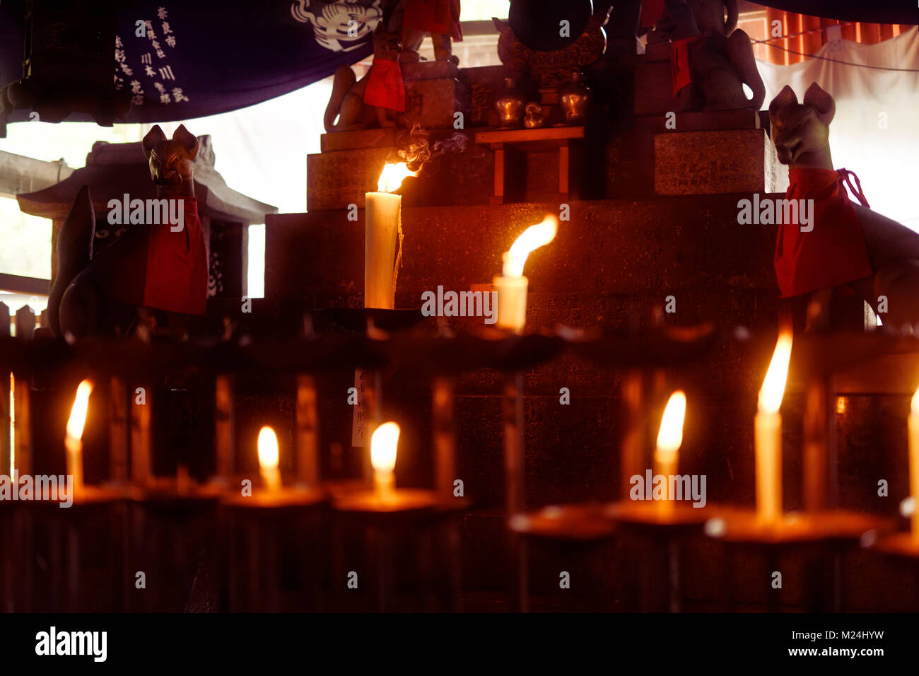 Uno dei santuari Shintoisti a Fushimi Inari complesso con candele accese e Kitsune volpi. Fushimi Inari-Taisha santuario di testa a Kyoto, Giappone Foto Stock