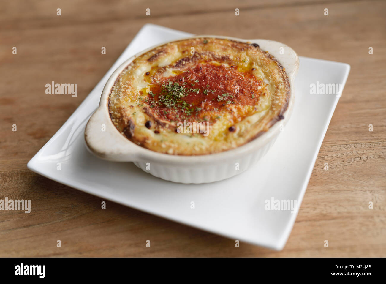 Vegano marrone cremosa casseruola di riso con salsa bianca, piatto su una tavola di legno, cibo vegetariano ancora in vita. Kyoto, Giappone. Foto Stock