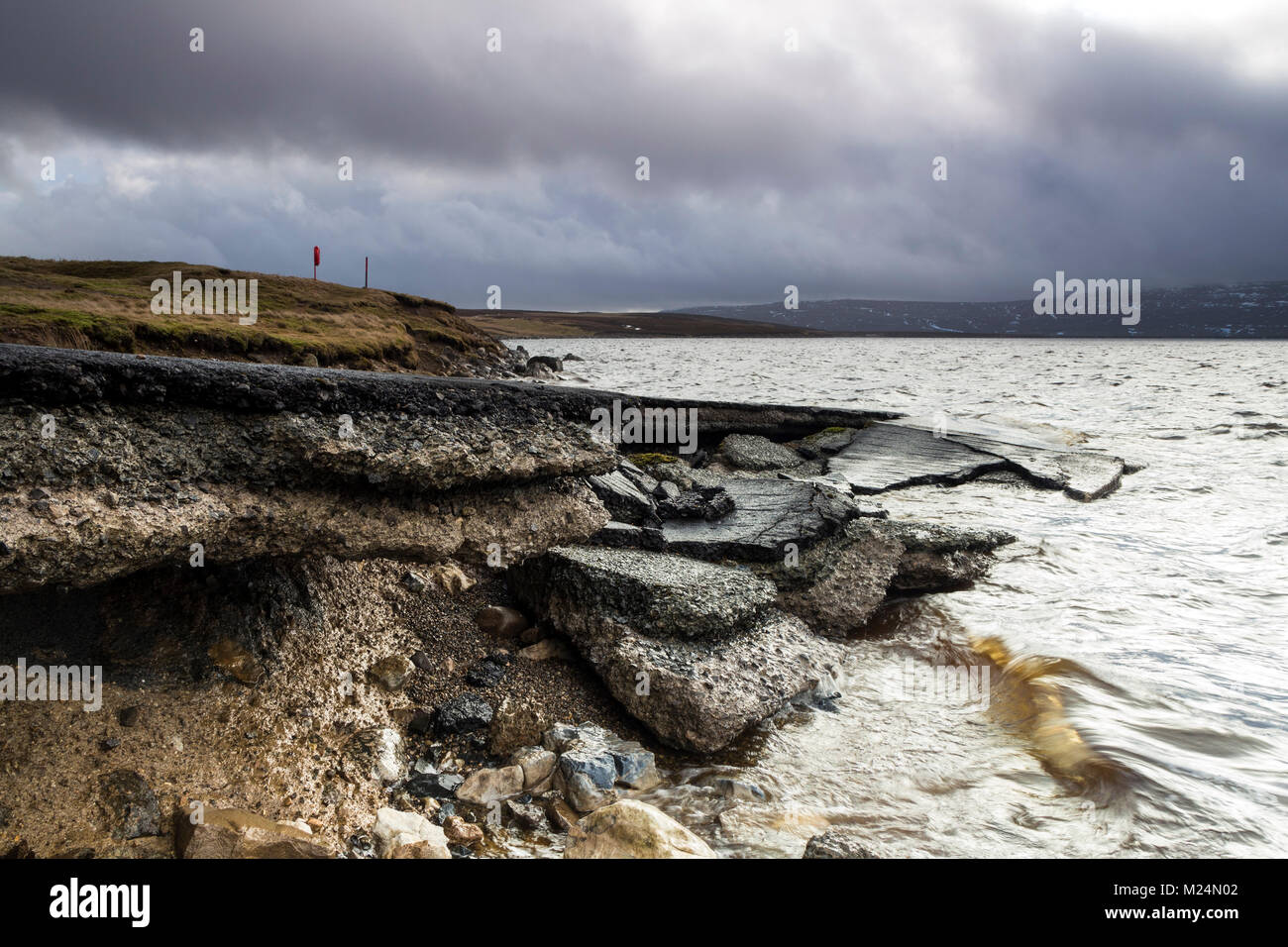 Scalo eroso dall azione di onda di minare la strada asfaltata, Mucca Serbatoio verde, Superiore Teesdale, County Durham, Regno Unito. Foto Stock
