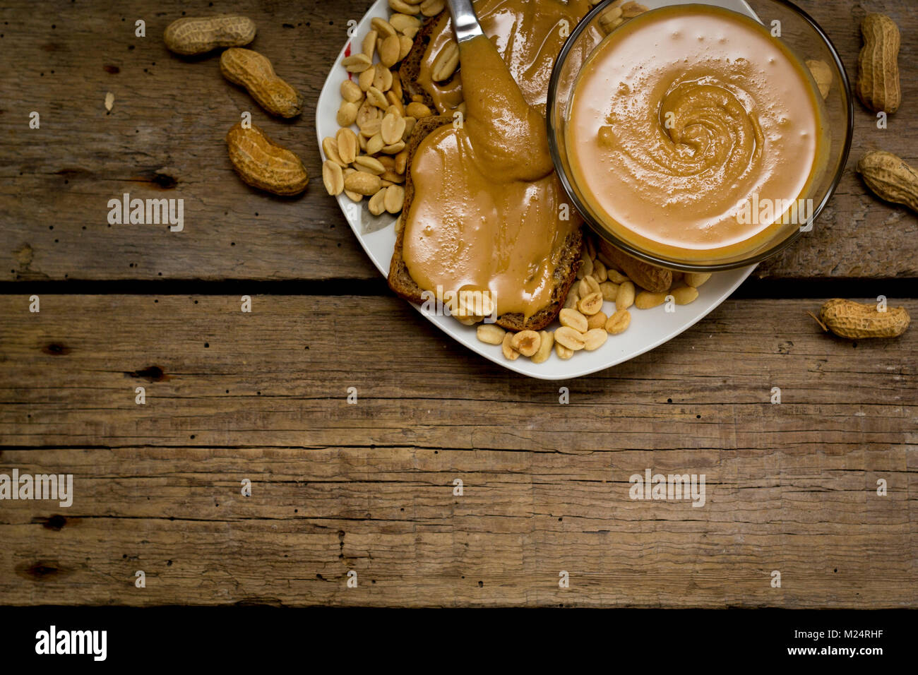 Burro di arachidi panini con ingredienti sul tavolo di legno. Foto Stock