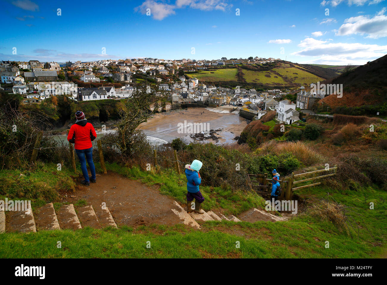 Cornwall, Regno Unito. Walkers godendo il sentiero costiero che si affaccia sul villaggio di Port Isaac sulla North Cornish Coast su una fredda e soleggiata giornata di febbraio. Foto Stock