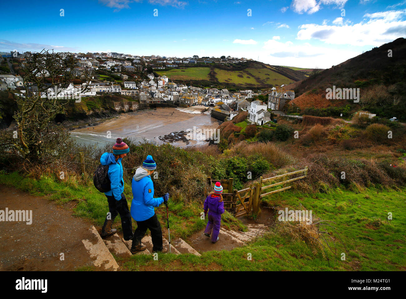 Cornwall, Regno Unito. Walkers godendo il sentiero costiero che si affaccia sul villaggio di Port Isaac sulla North Cornish Coast su una fredda e soleggiata giornata di febbraio. Foto Stock