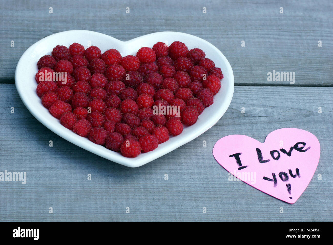 Cuore rosso fatta di lampone. Fresche, succosa e fragrante di frutti di bosco Lamponi sono posati su un piatto. Foto Stock