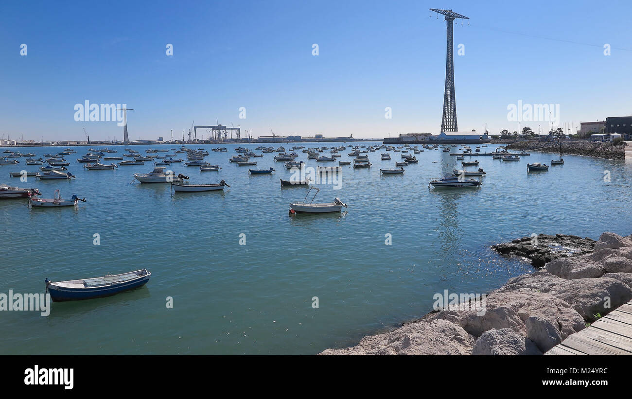 Piccole barche di legno ancorato nel porto di Cadice con i cantieri in background Foto Stock