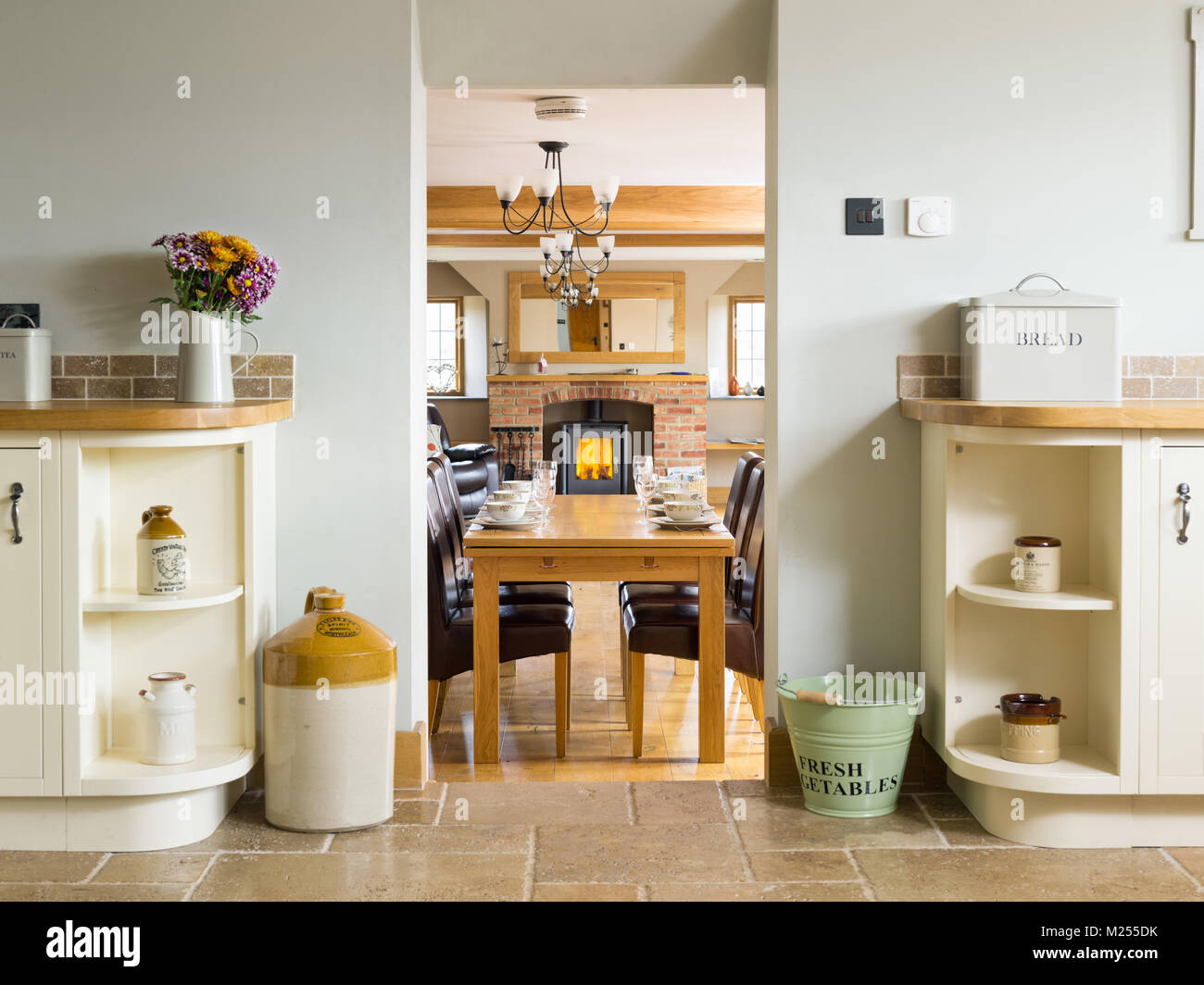 Una vista attraverso una casa dalla cucina attraverso il soggiorno per una stufa a legna in un mattone costruito tino Foto Stock
